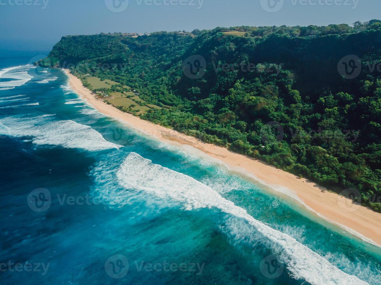 Above shot of coastline with ocean waves and tropical sandy beach in Bali. photo