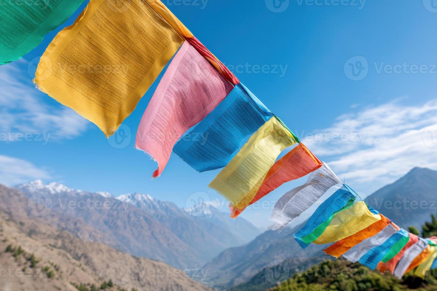 Colorful prayer flags fluttering in the wind in the Himalayas with snowy mountains in the background photo