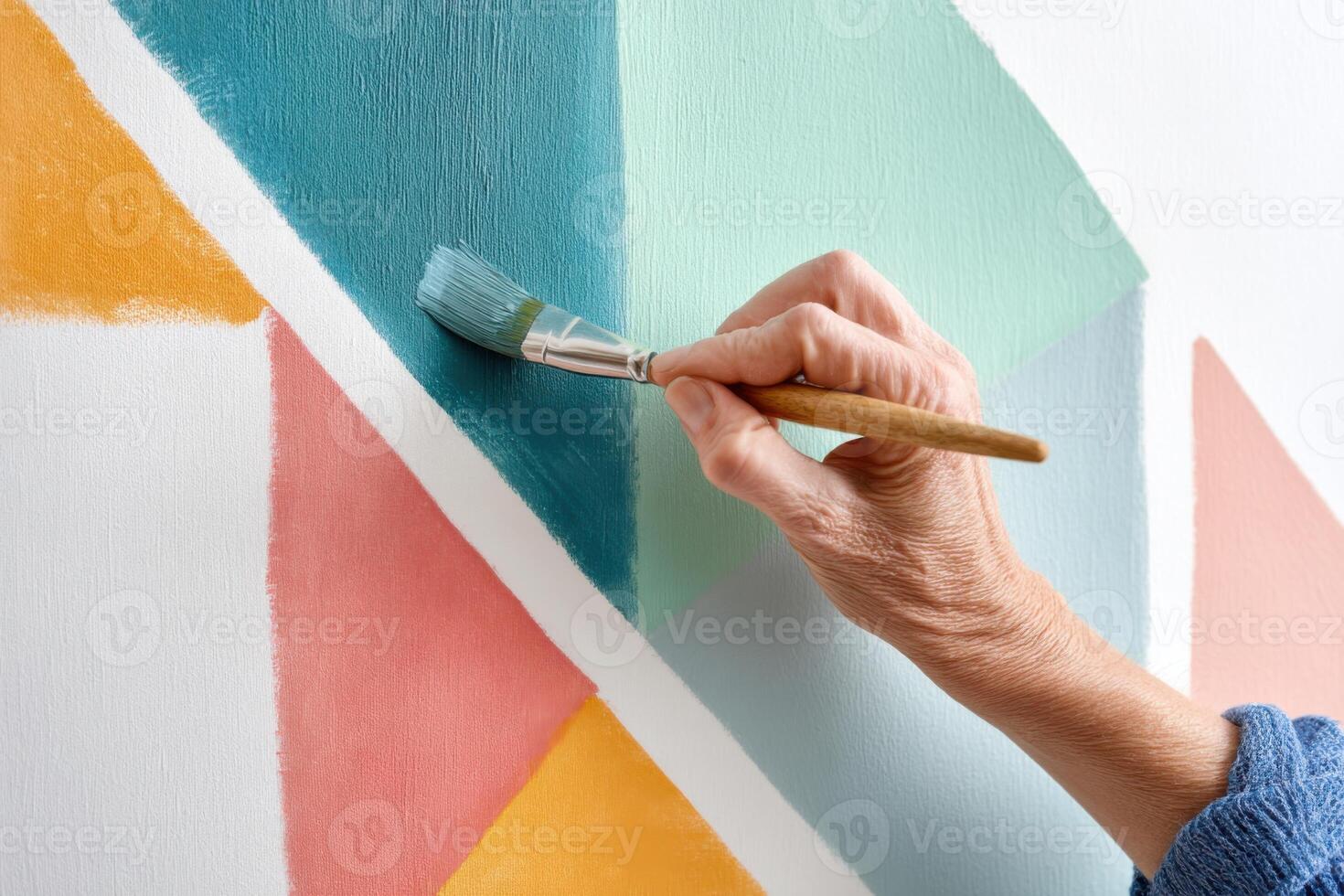 Creative hand painting geometric shapes on wall with vibrant colors and artistic brush strokes showcasing modern home decor and personal expression in interior design photo