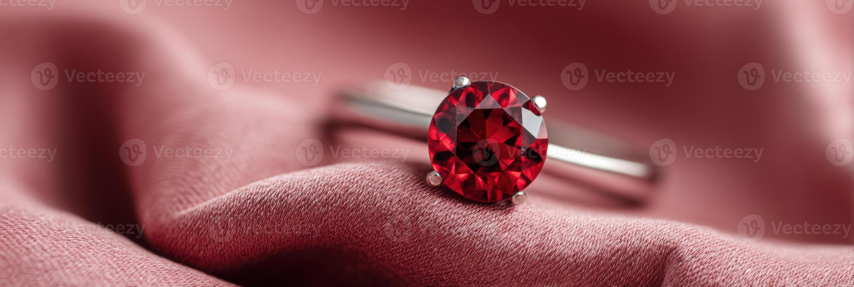 Stunning close-up of a brilliant red gemstone ring resting elegantly on soft pink fabric, showcasing intricate details and luxurious design with copy space for text photo