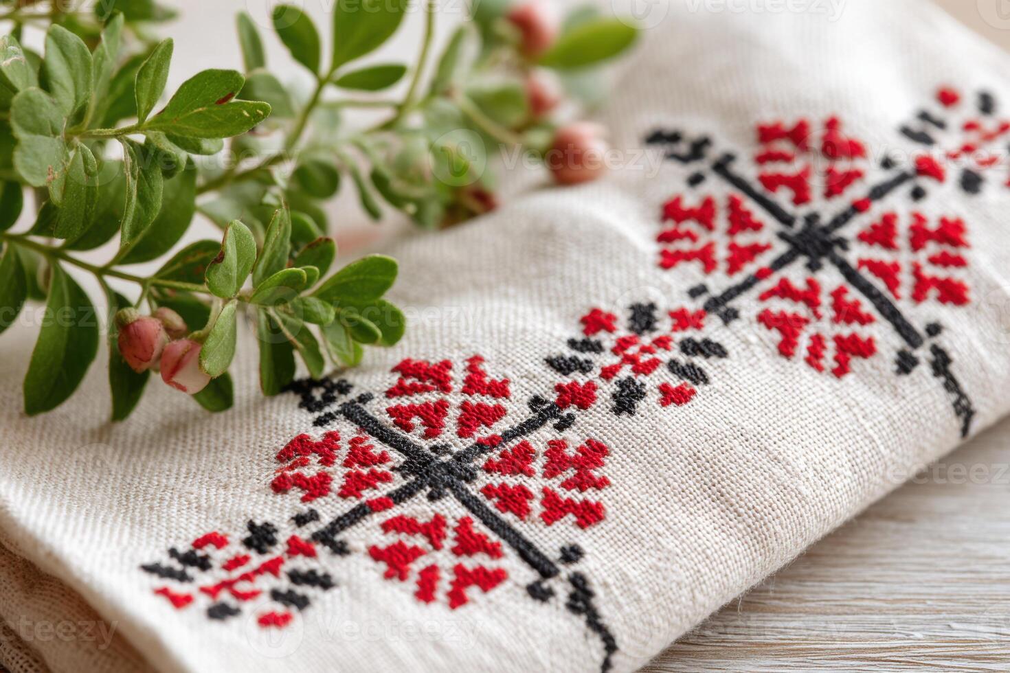 Palestinian tatreez embroidery displayed on fabric, featuring intricate red and black floral patterns, surrounded by fresh greenery, showcasing traditional craftsmanship and cultural heritage photo