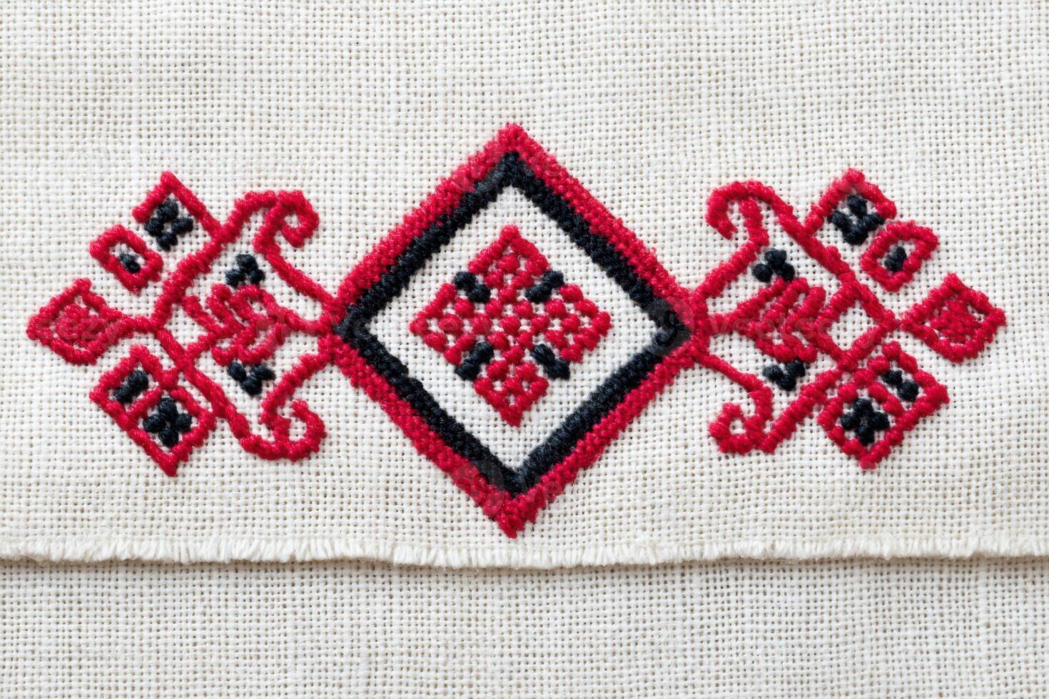 Ukrainian cross-stitch embroidery pattern featuring intricate red and black designs on a natural fabric background, showcasing traditional craftsmanship and cultural artistry photo