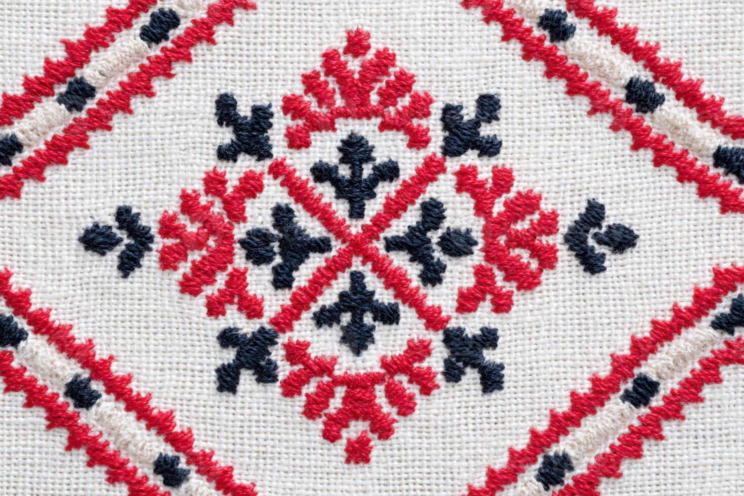 Ukrainian cross-stitch embroidery pattern featuring intricate geometric designs in red and black threads on a natural fabric background, showcasing traditional craftsmanship and artistic heritage photo