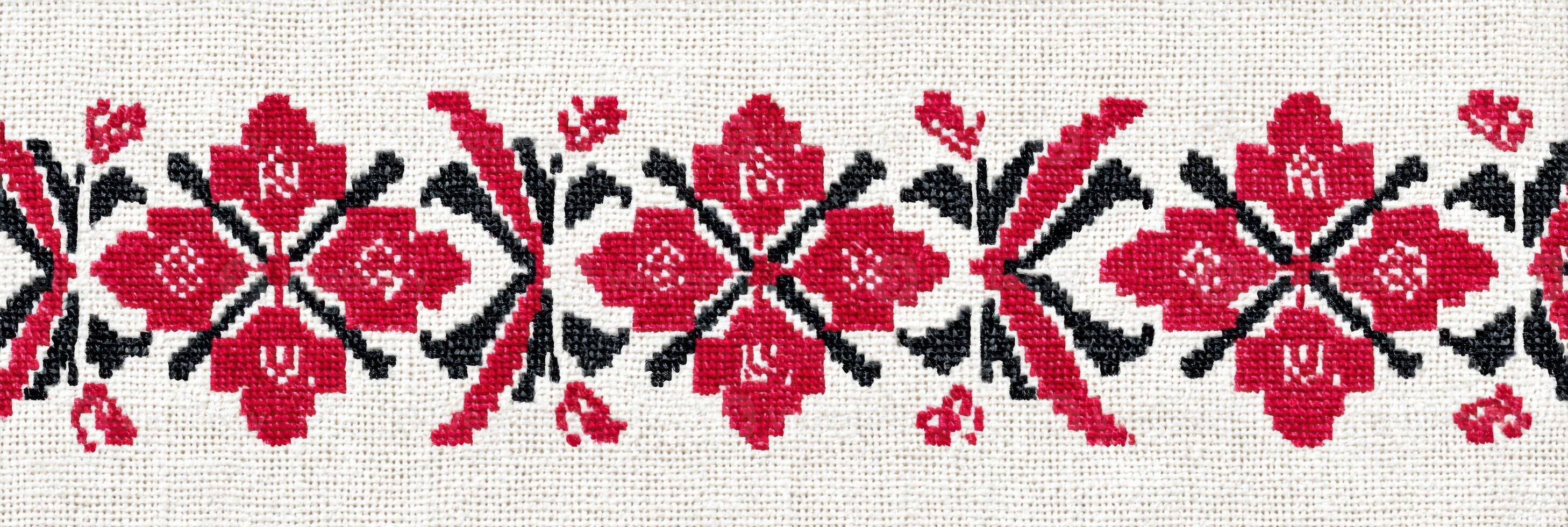 Ukrainian cross-stitch embroidery pattern featuring intricate floral designs in vibrant red and black threads on a light fabric background, showcasing traditional craftsmanship and cultural artistry photo