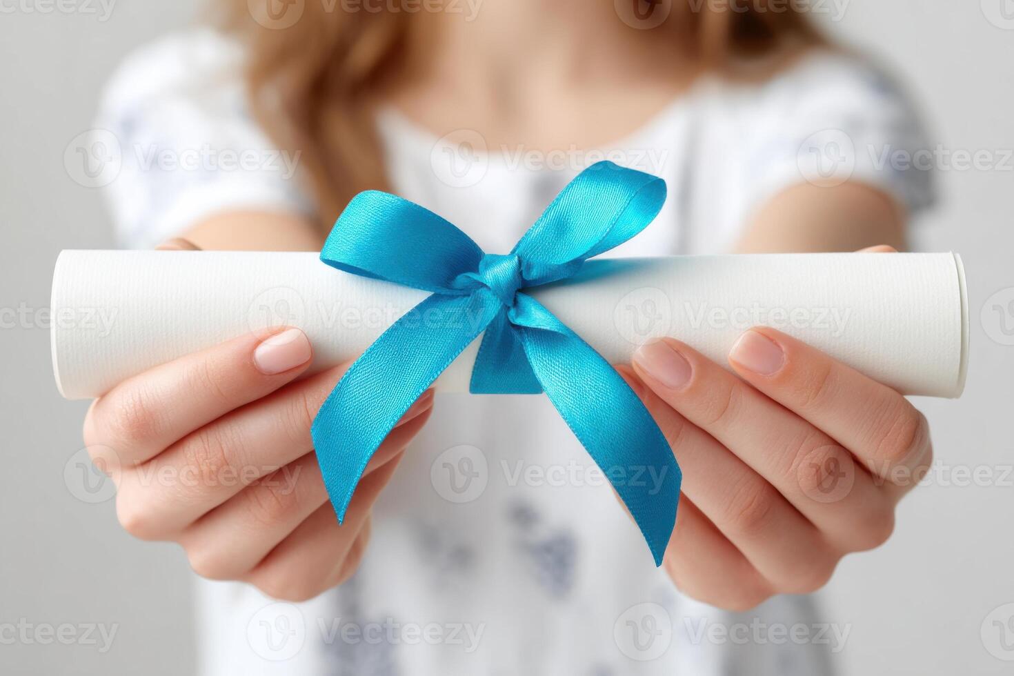 Young woman holding a rolled diploma tied with a blue ribbon, showcasing achievement and celebration, symbolizing education and success in a bright, inviting environment photo