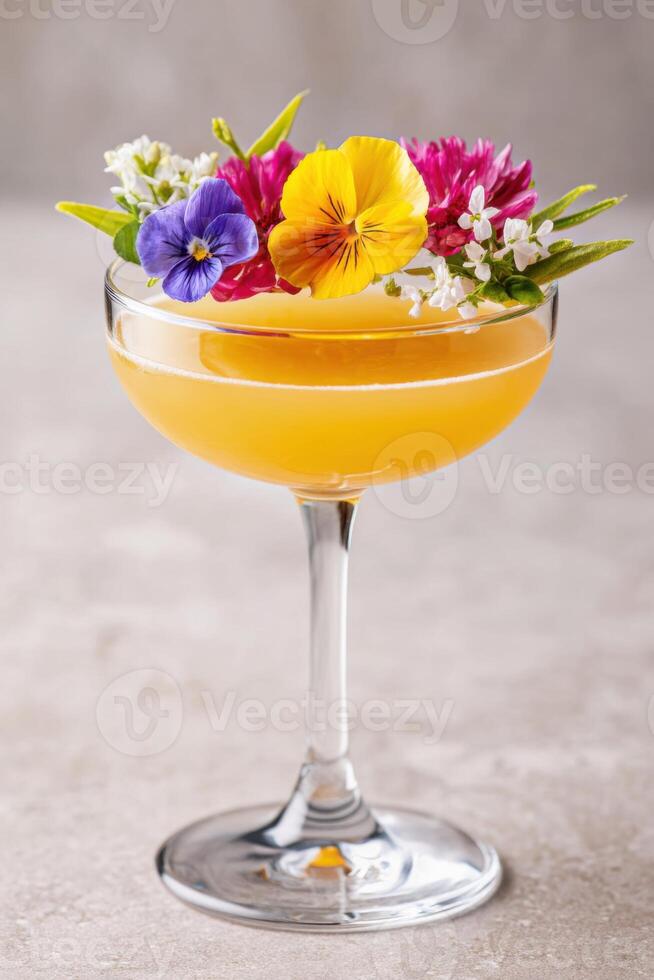 Refreshing kombucha mocktail garnished with edible flowers in a coupe glass photo