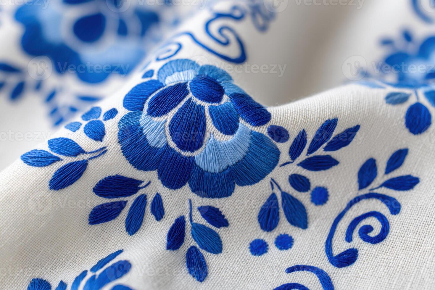 Close-up of Gzhel blue hand embroidery featuring floral patterns on white linen photo