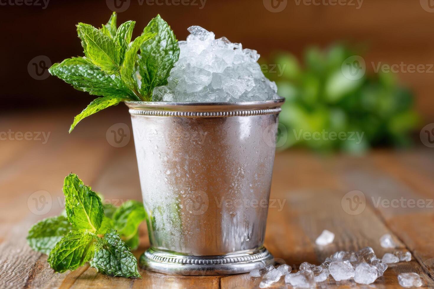 Refreshing mint julep cocktail is served in a silver cup with crushed ice photo