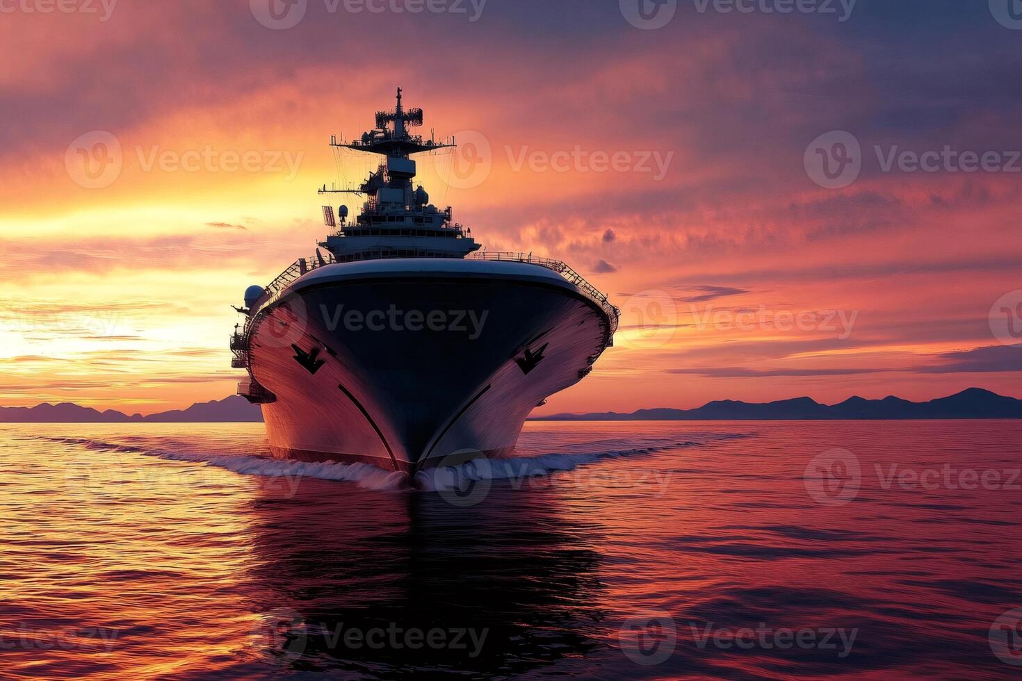 Aircraft carrier sailing on the ocean at sunset photo