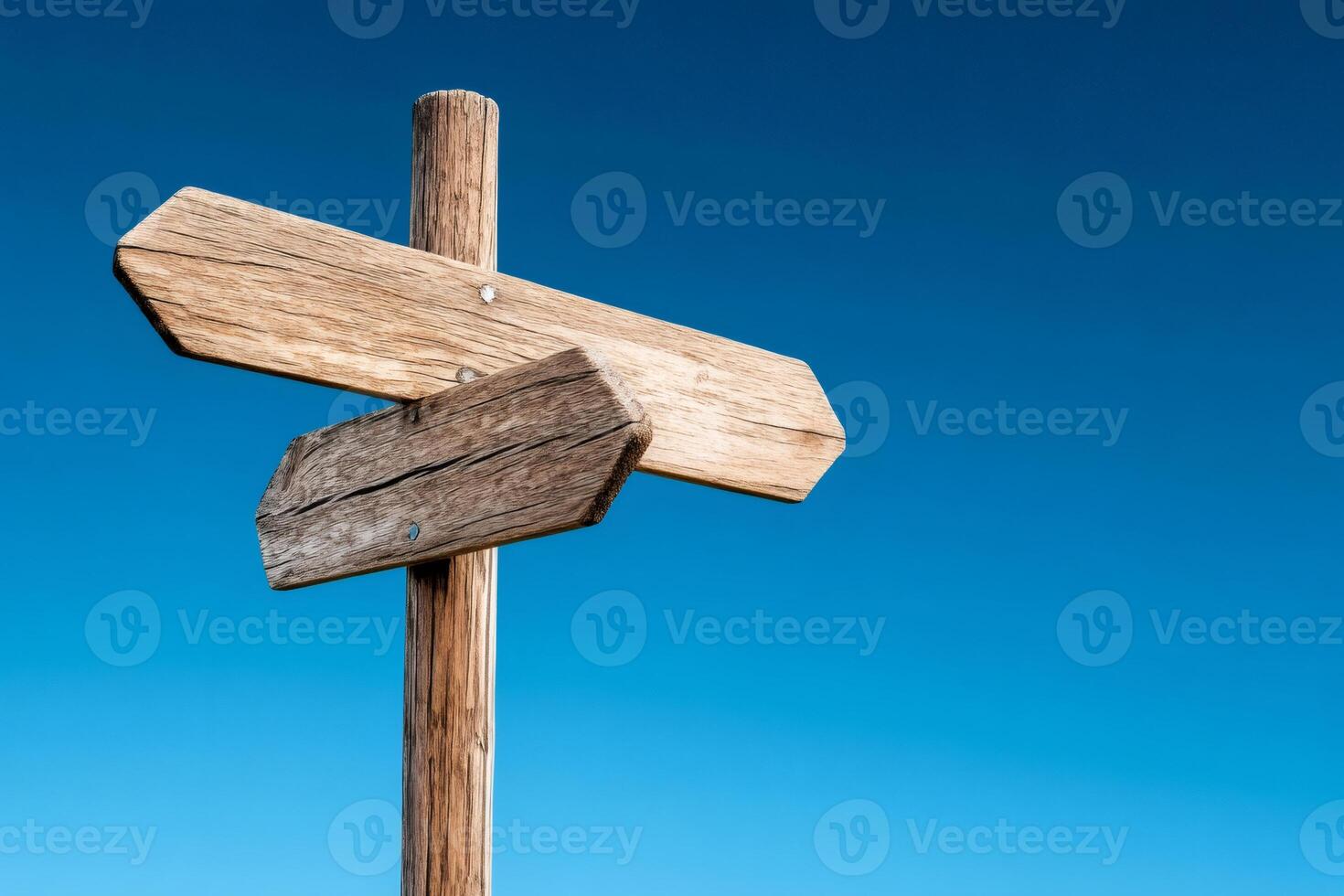 Wooden directional sign against blue sky pointing in two different directions photo