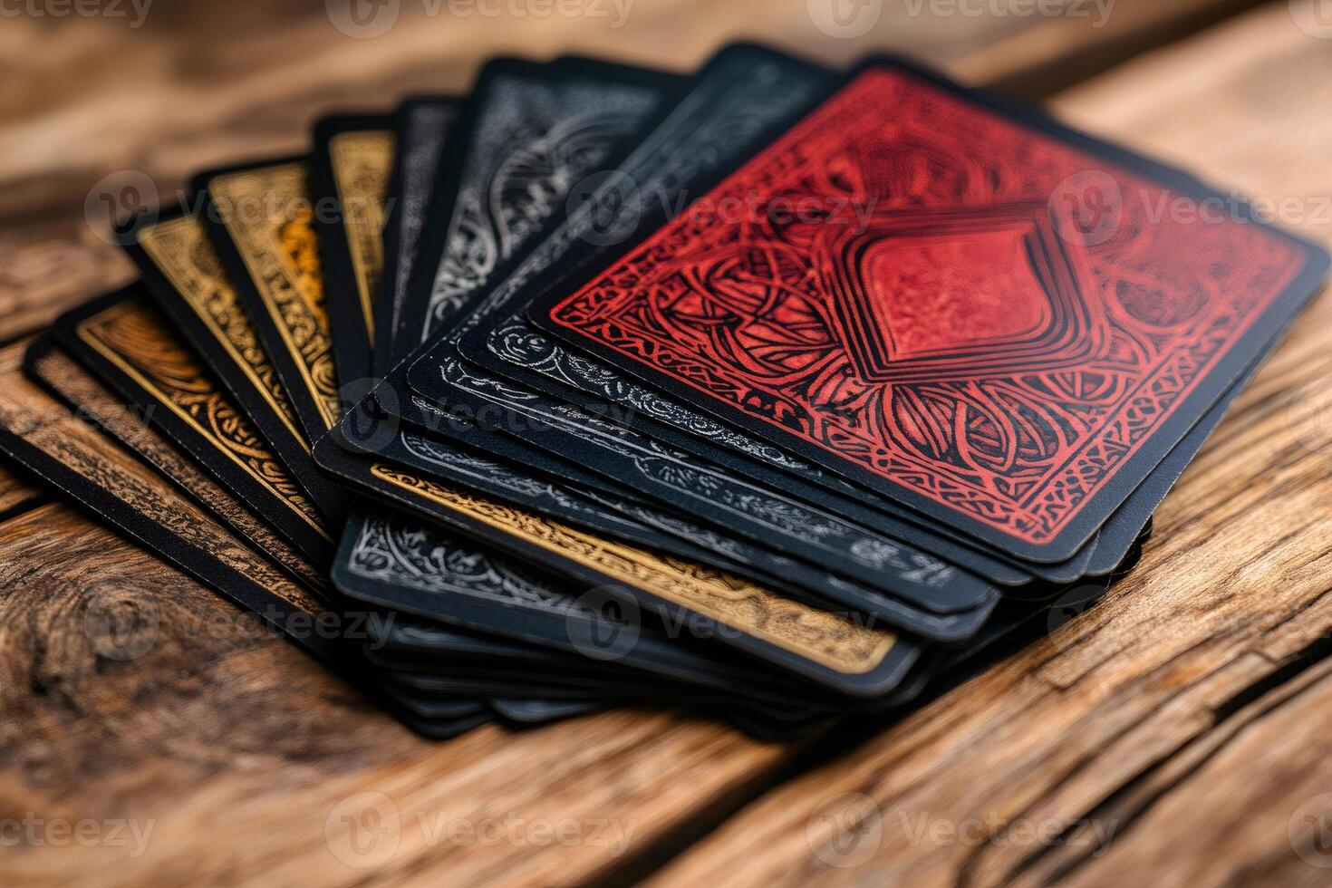 Deck of cards with intricate designs lying on wooden table photo