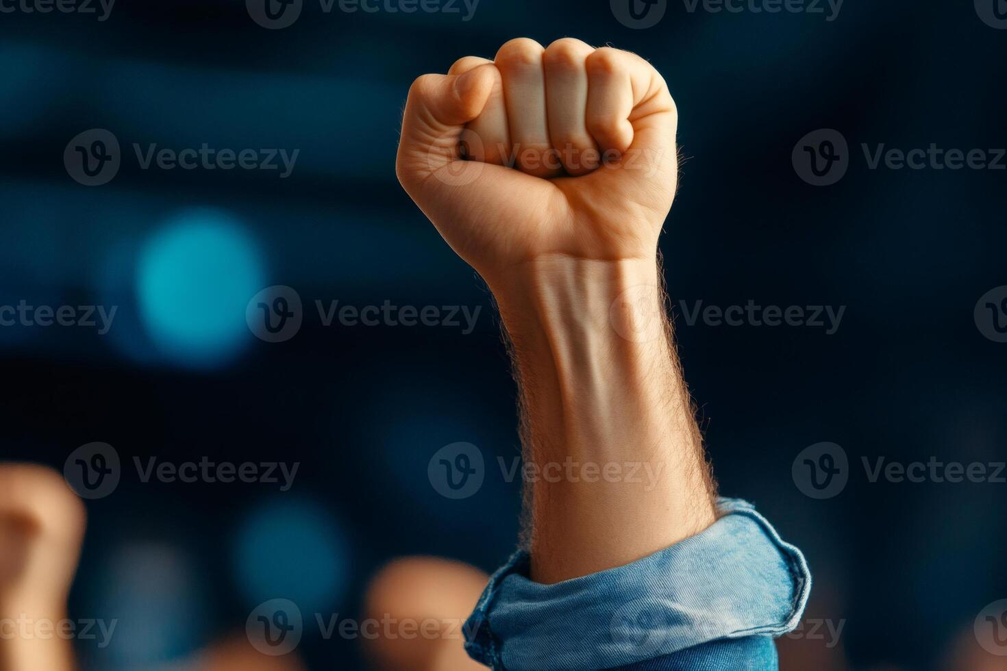 Man raising fist showing power and strength in a crowd photo