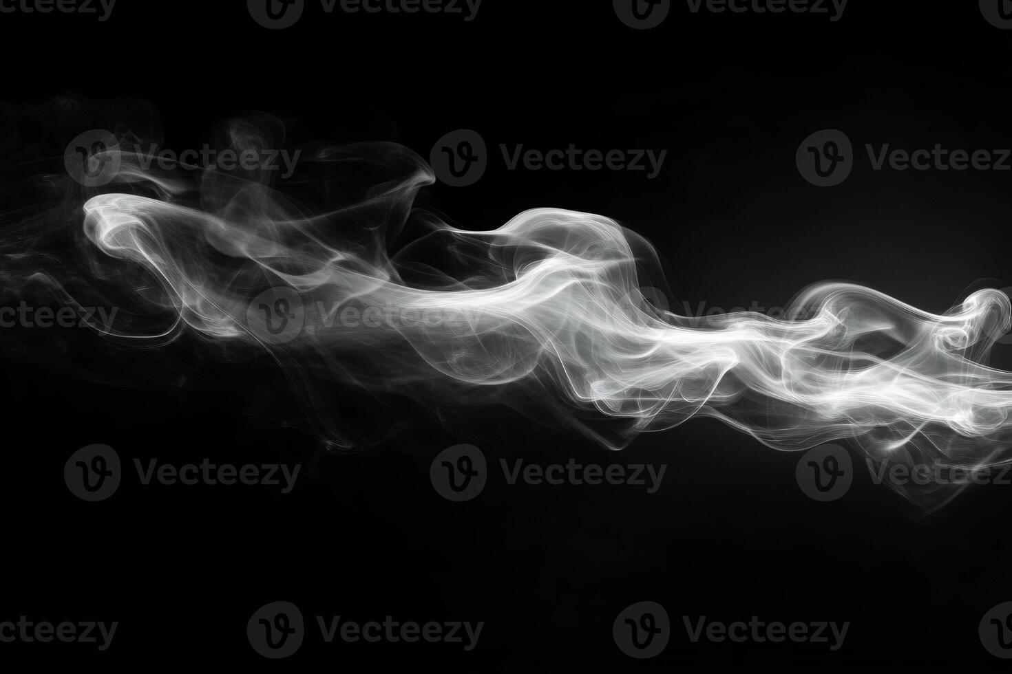 White smoke flowing on dark background creating abstract shapes photo