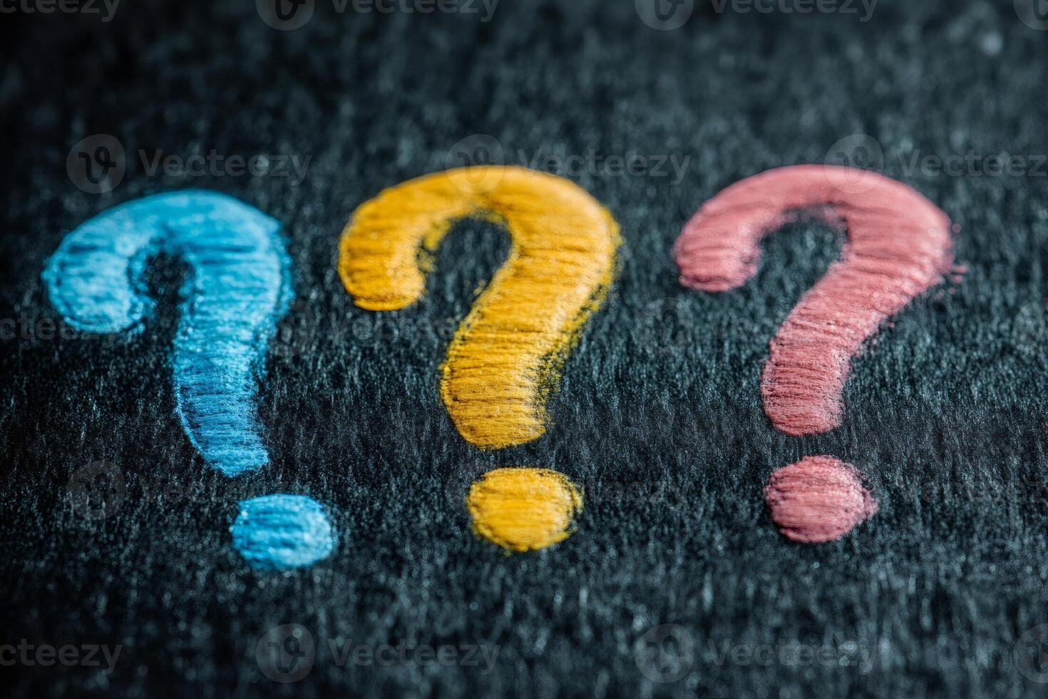 Three colorful question marks symbolizing uncertainty and curiosity on dark background photo