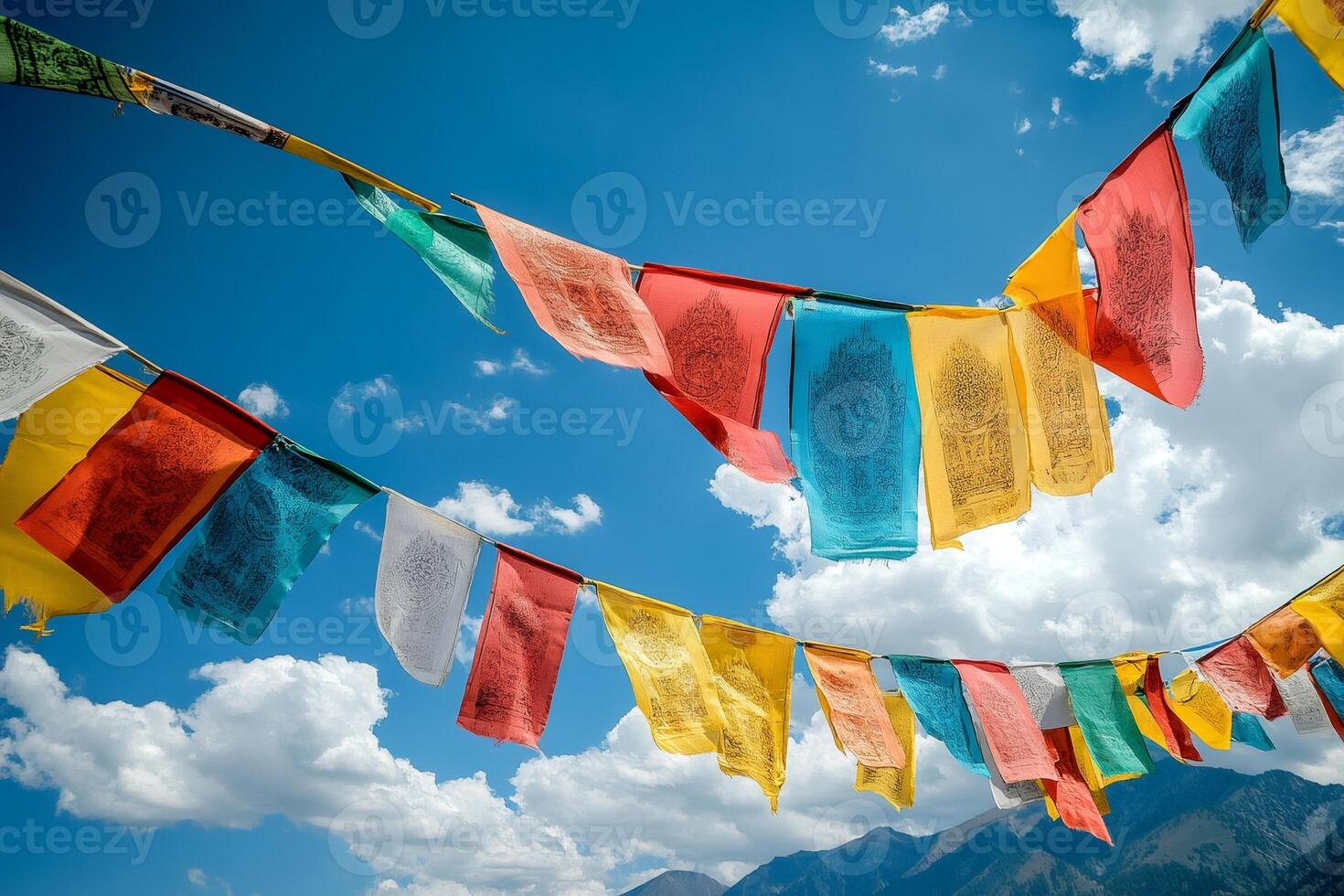Colorful prayer flags fluttering in the wind against blue sky photo