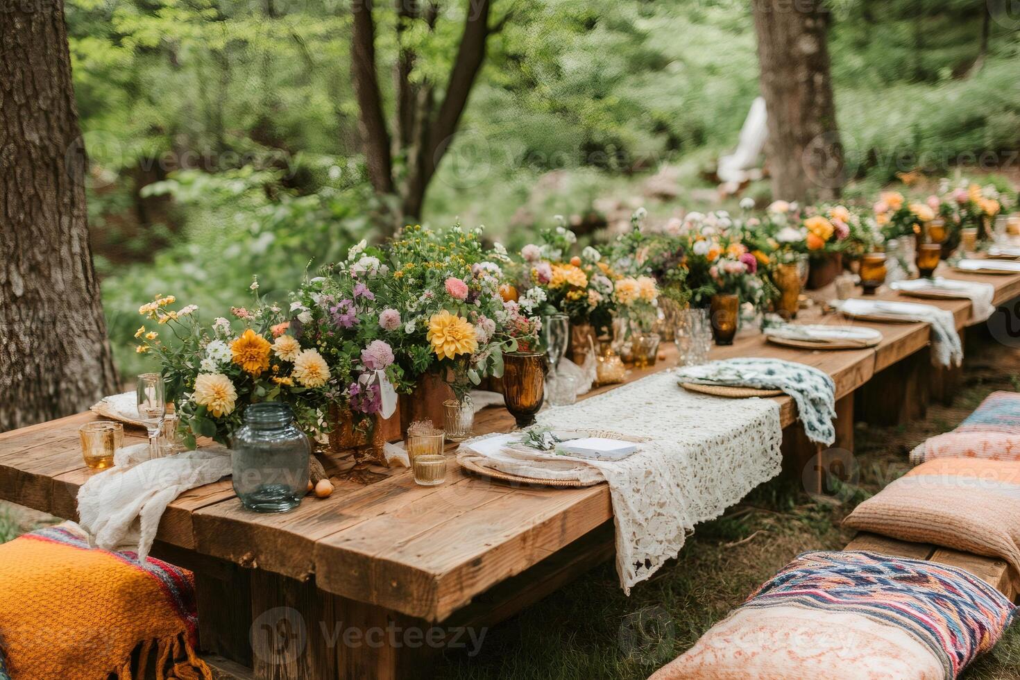 Rustic wedding reception table decorated with colorful flowers in the woods photo