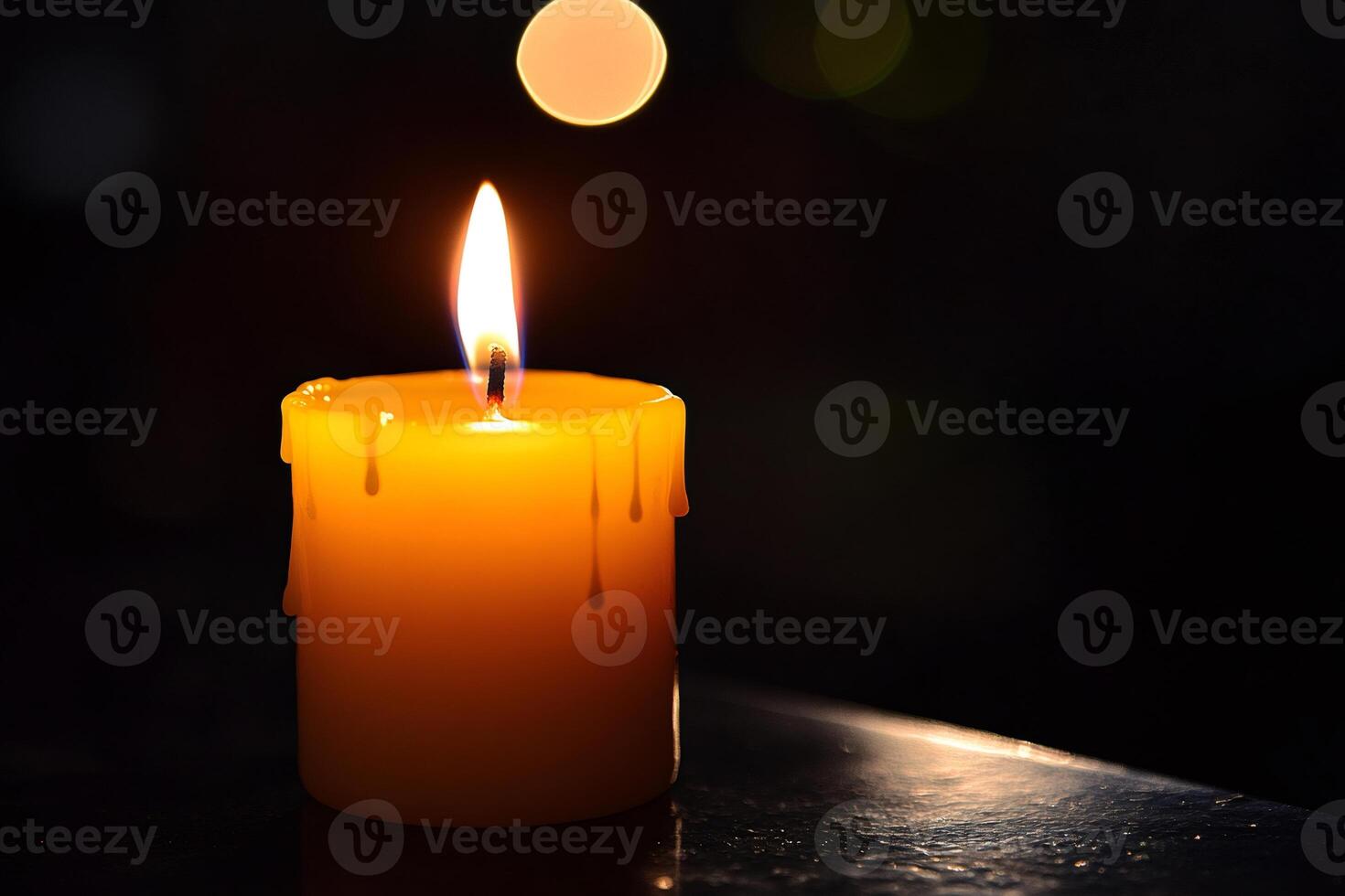 Burning candle melting and illuminating dark background with bokeh photo