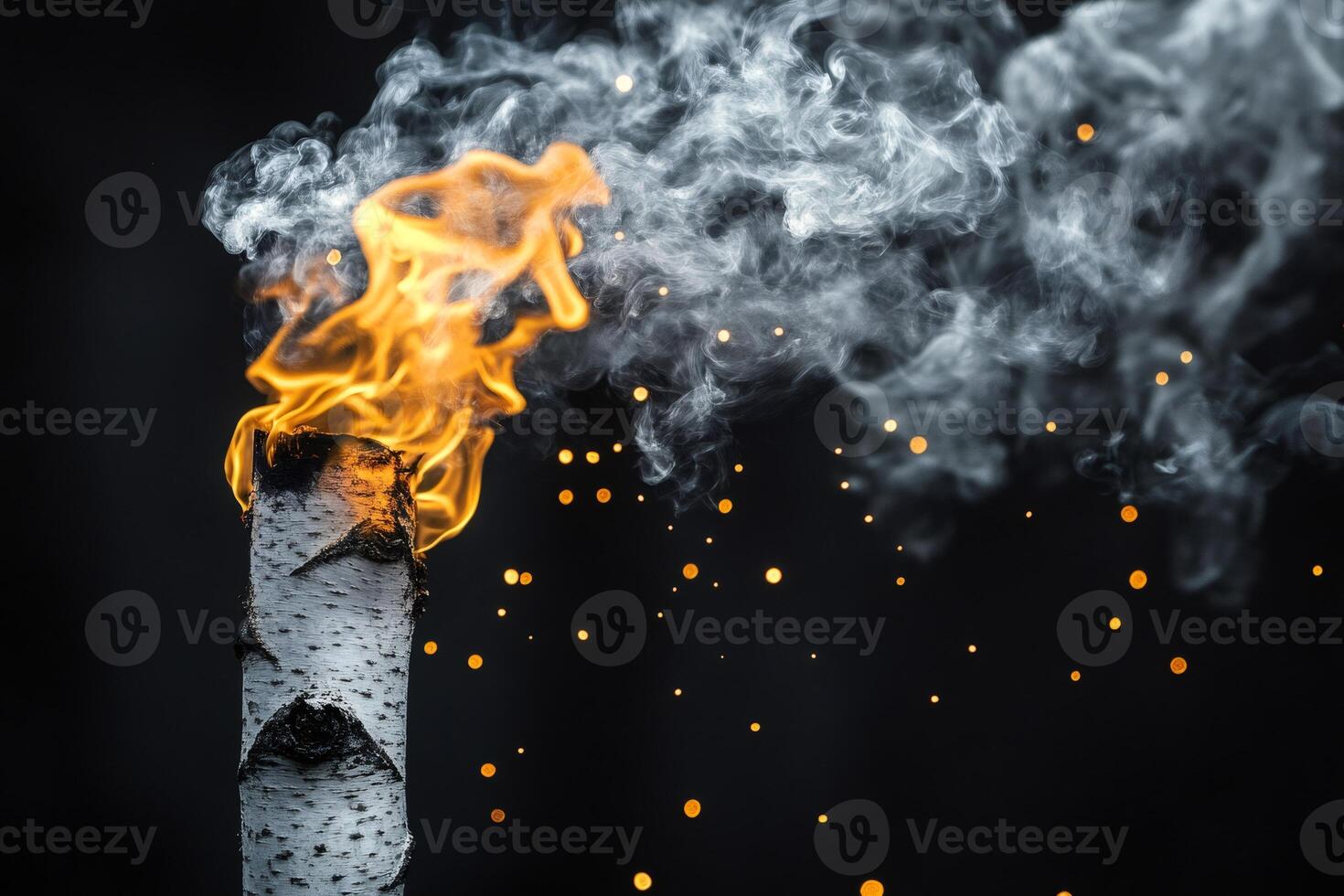 Birch torch burning with sparks and smoke on black background photo