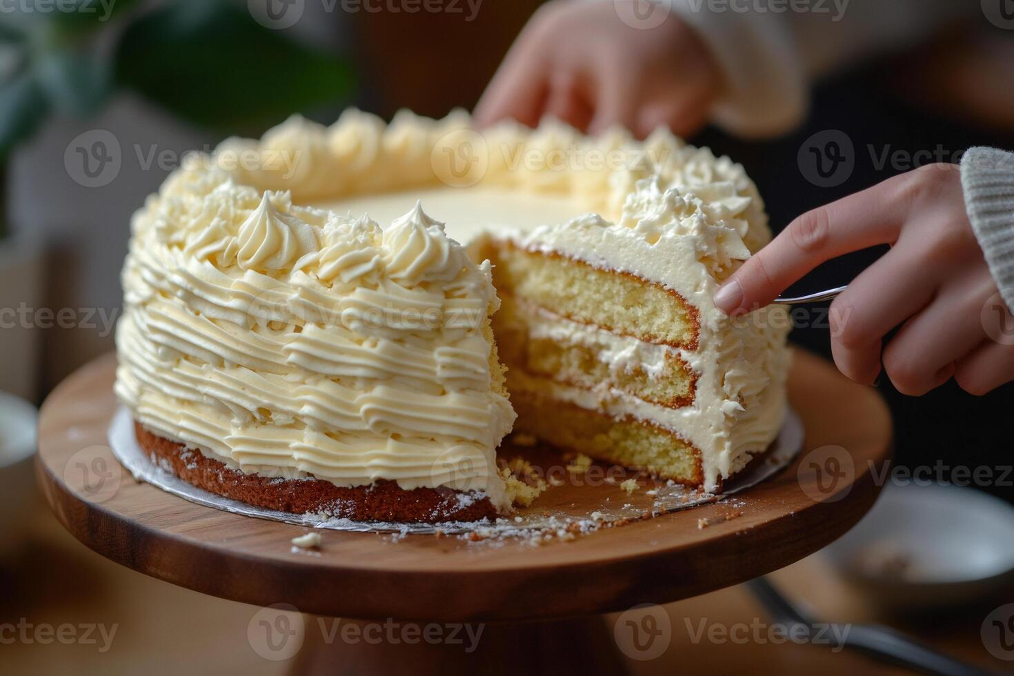 Pastry chef cutting a slice of delicious layered cake with buttercream frosting photo