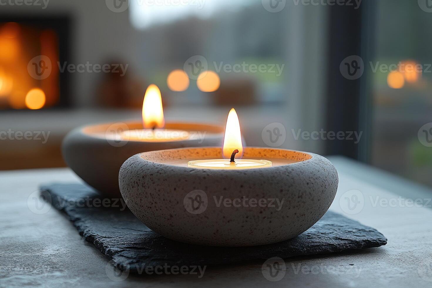 Two lit candles resting on stone creating tranquil spa ambiance at sunset photo