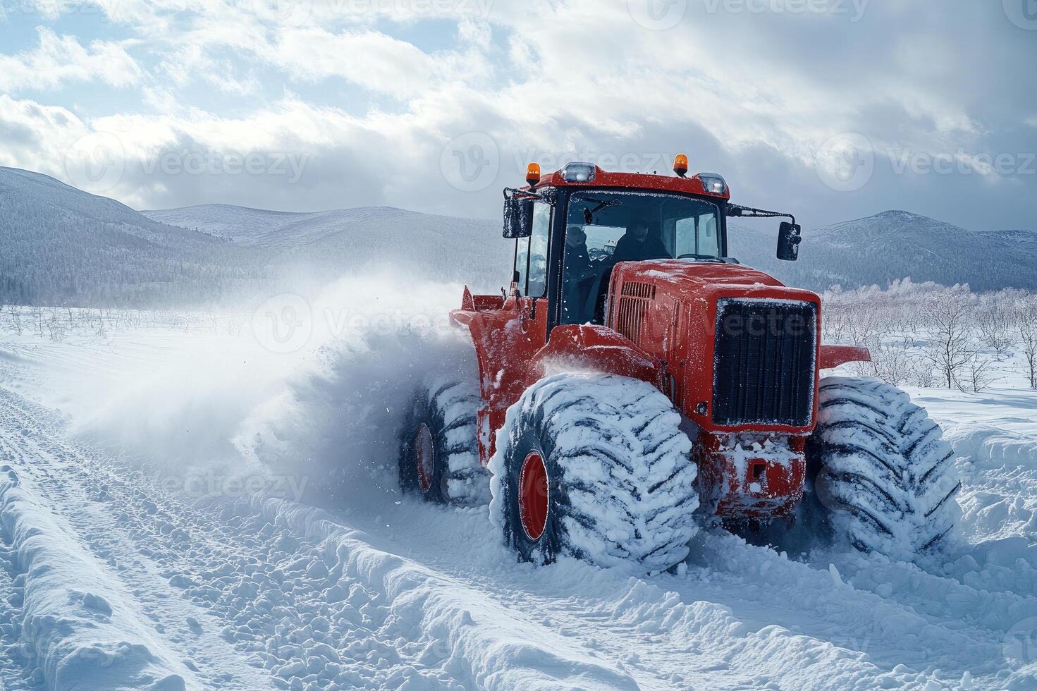 Red tractor removing snow from a mountain road in winter photo