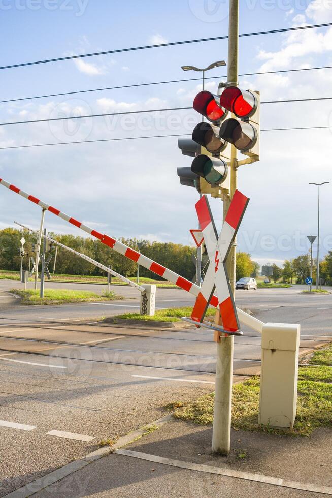 Railway infrastructure ensuring safety. Closing barriers and flashing red traffic lights. ban on entering a railway and road crossing. photo