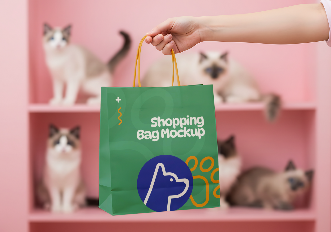 A hand holds a green shopping bag mockup in front of several cats sitting on shelves psd