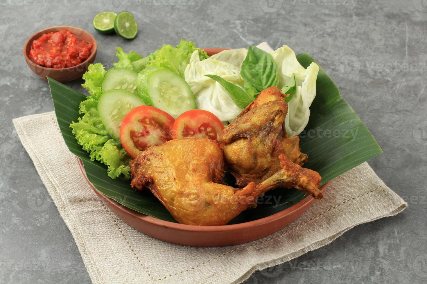 Ayam Goreng with Sambal, Deep Fried Spiced Fried Chicken with Fresh Vegetabble Lalapan photo