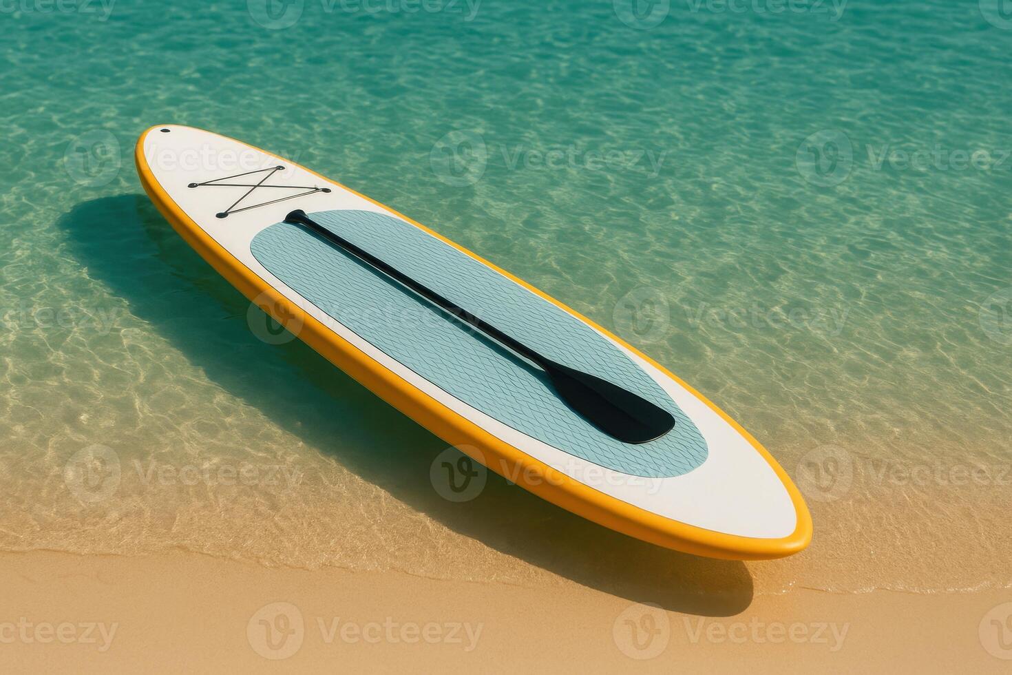 Bright paddleboard with black paddle floats at the edge of turquoise sea and sandy beach. A serene tropical image perfect for vacation themes, water sports, and summer lifestyle visuals photo