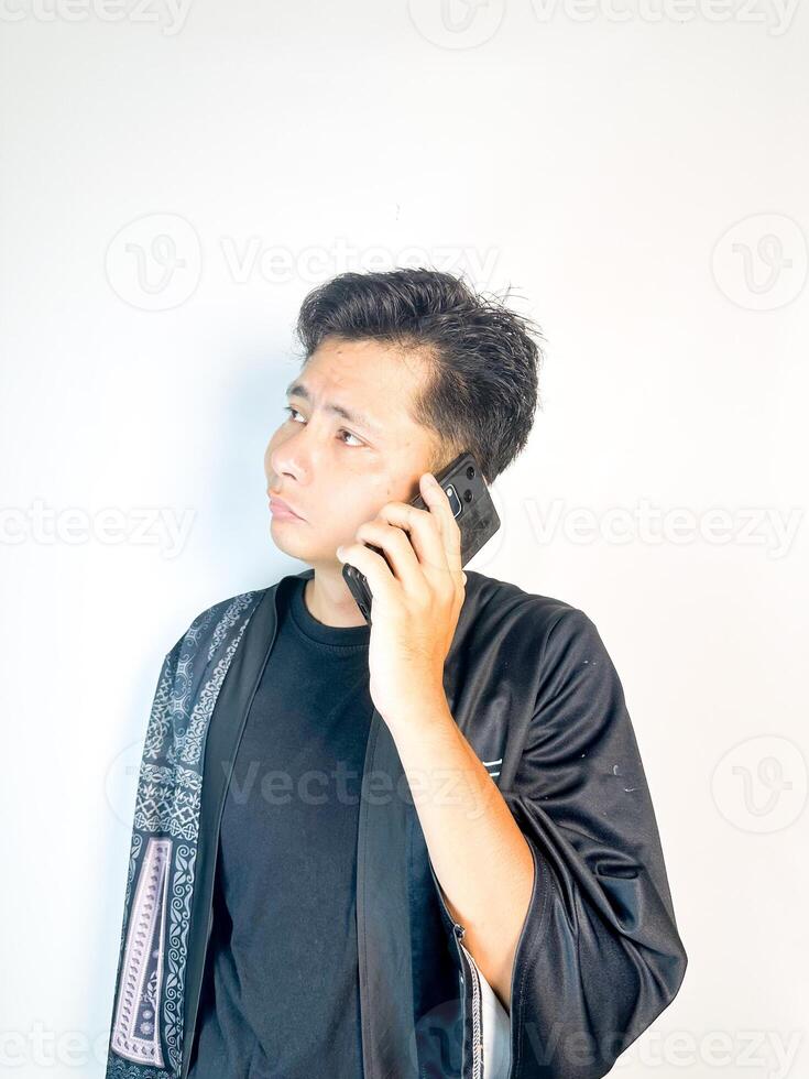 A man in a robe talking on a cell phone photo