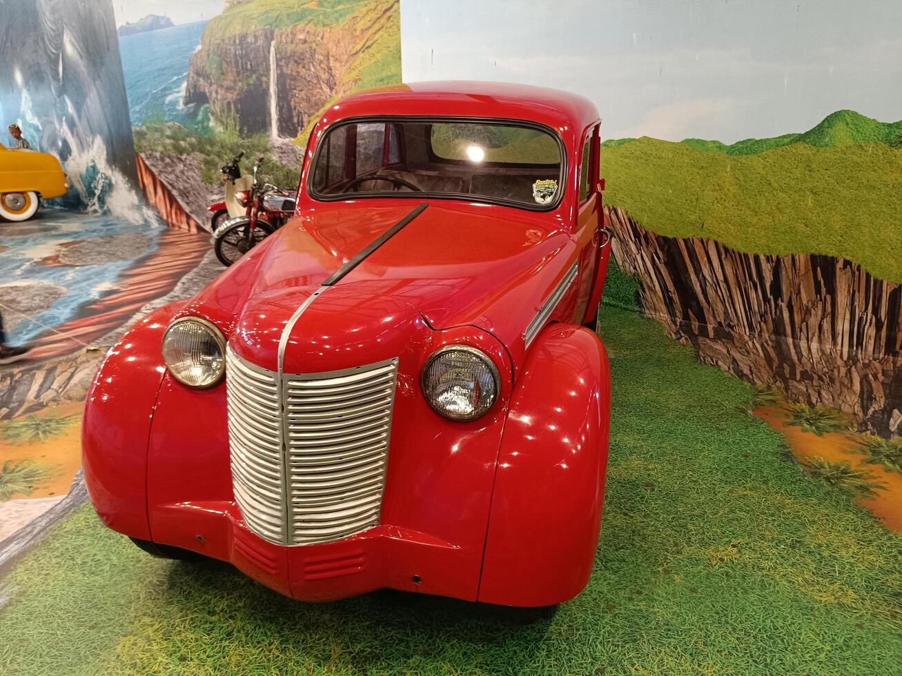 solo, central java - indonesia, april 22, 2025, Classic Red Vintage Car in Scenic Landscape Photo