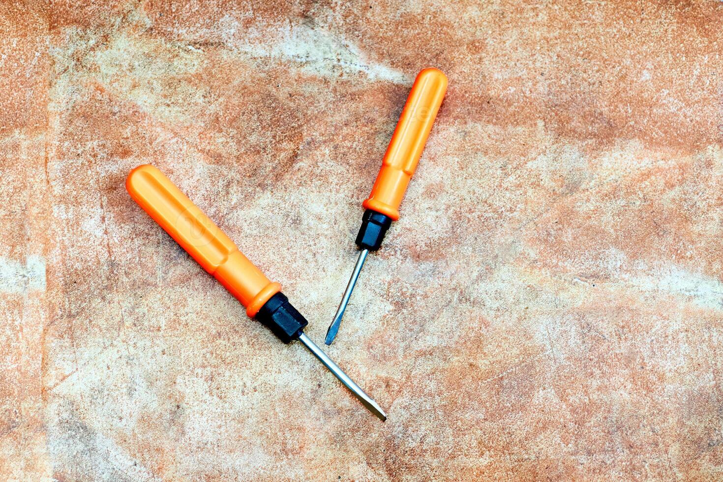 Orange screwdrivers on marble photo