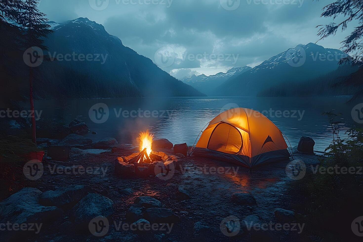 Tranquil Mountain Camping by a Lake at Dusk with Glowing Tent and Campfire photo