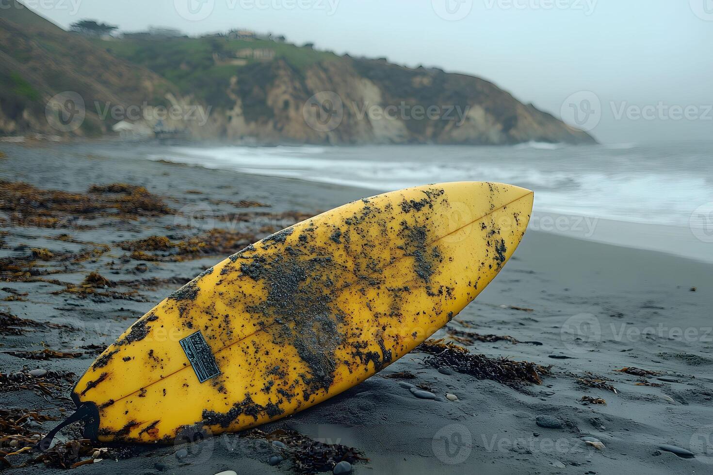 Surfboard on Misty Beach with Rocky Cliffs and Overcast Sky - Coastal Adventure Concept photo