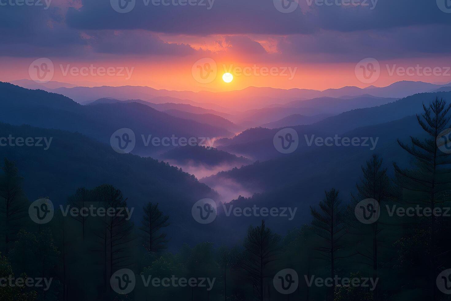 Sunset Over Mountain Range with Misty Valleys and Silhouetted Trees photo