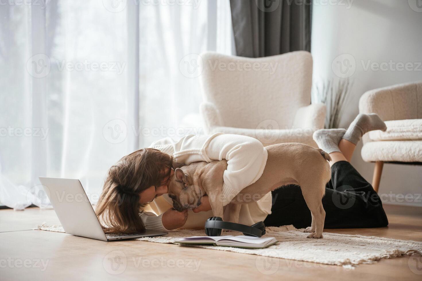 Wooden, floor,. With laptop. Young woman is with her pug dog at home photo