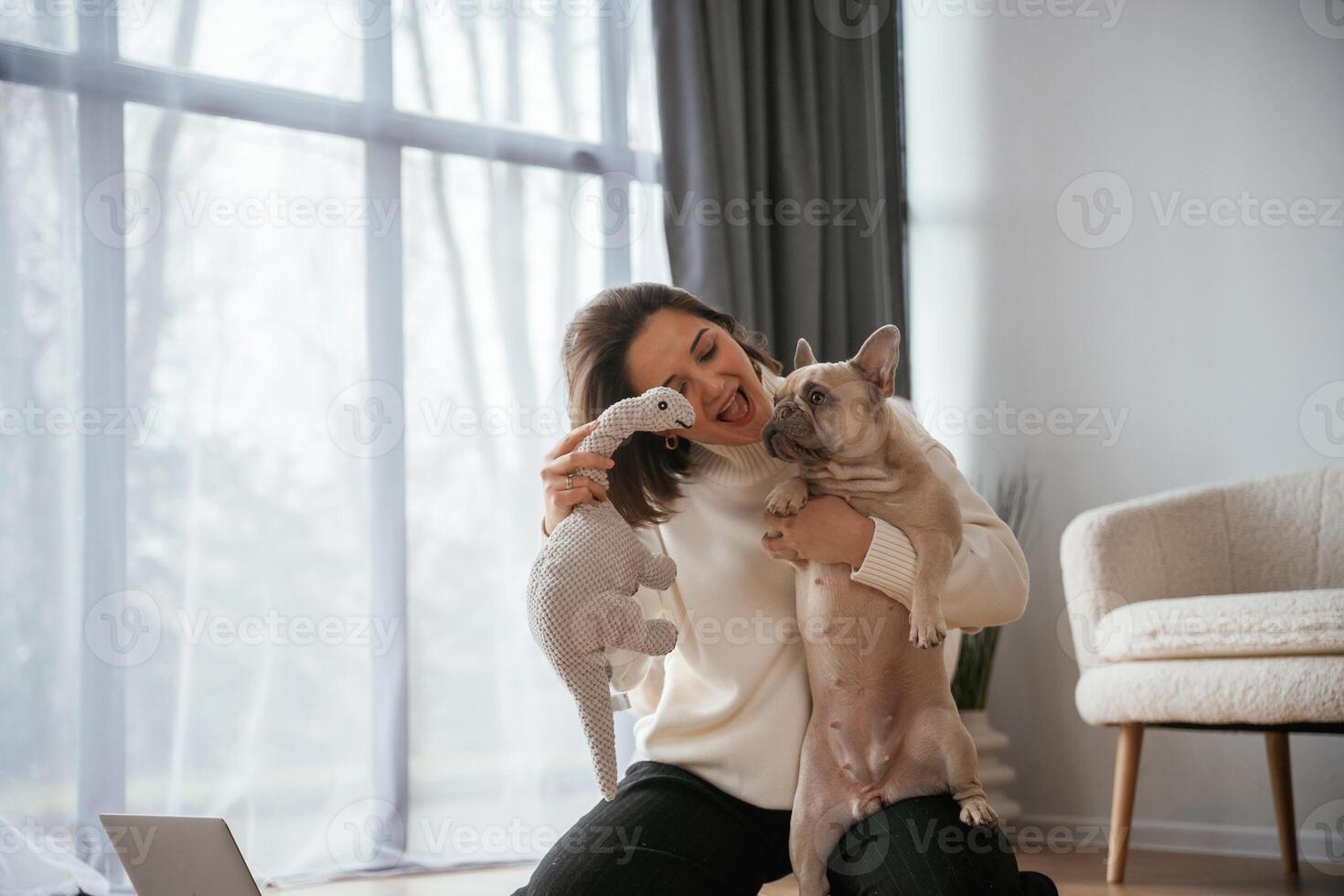 Conception of, love, and care. Young woman is with her pug dog at home photo