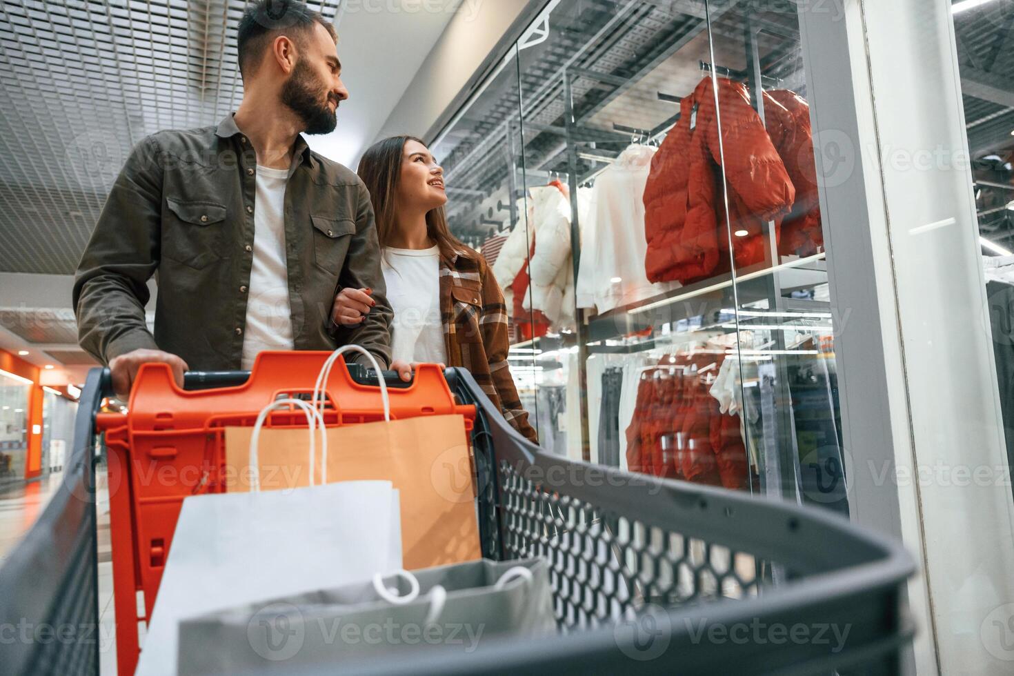 Many of the clothes on the side.. Young couple are in supermarket together photo