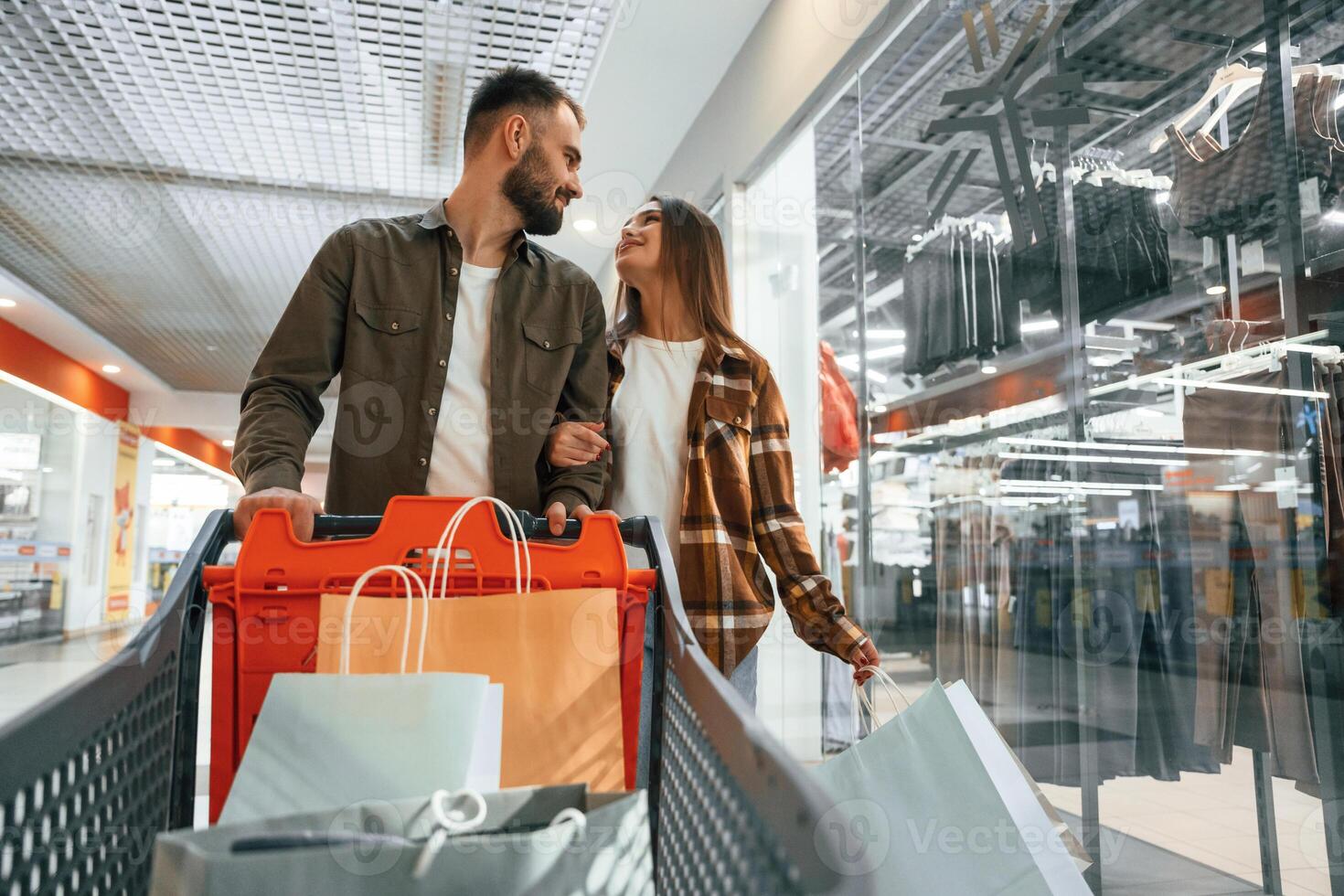 Buy me, new clothes... Young couple are in supermarket together photo