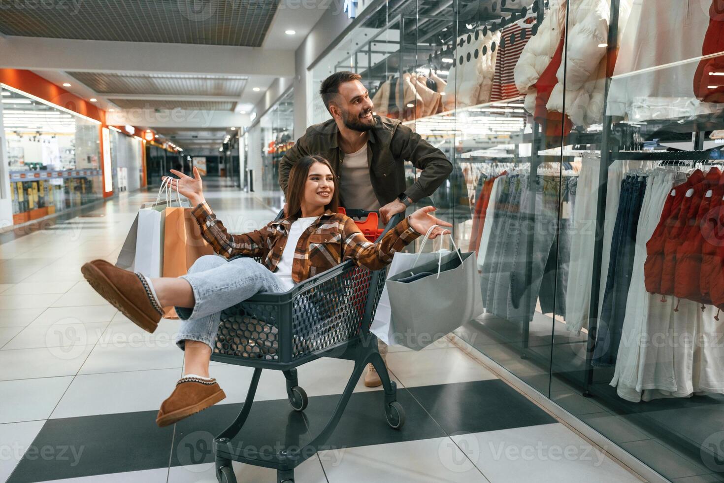Having ,fun, riding in the ,cart. Young couple are in supermarket together photo
