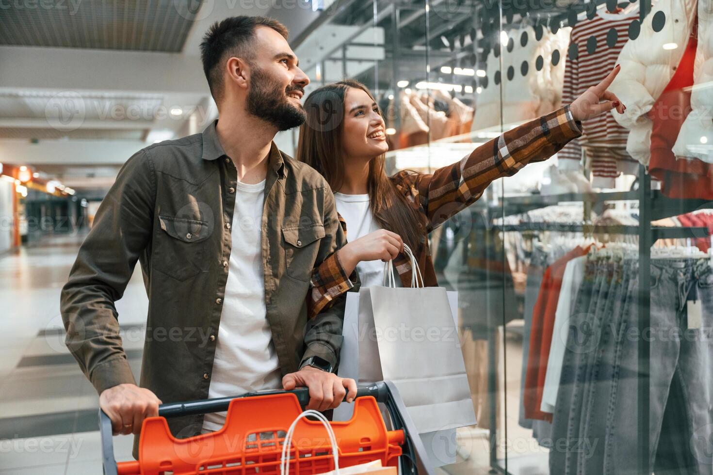 Buy me new c,lothes. Young couple are in supermarket together photo