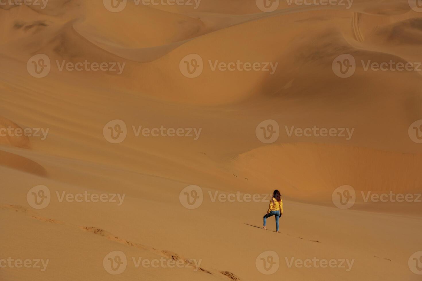 Distant view of woman that, is walking in the sands of Namibia, Africa desert photo