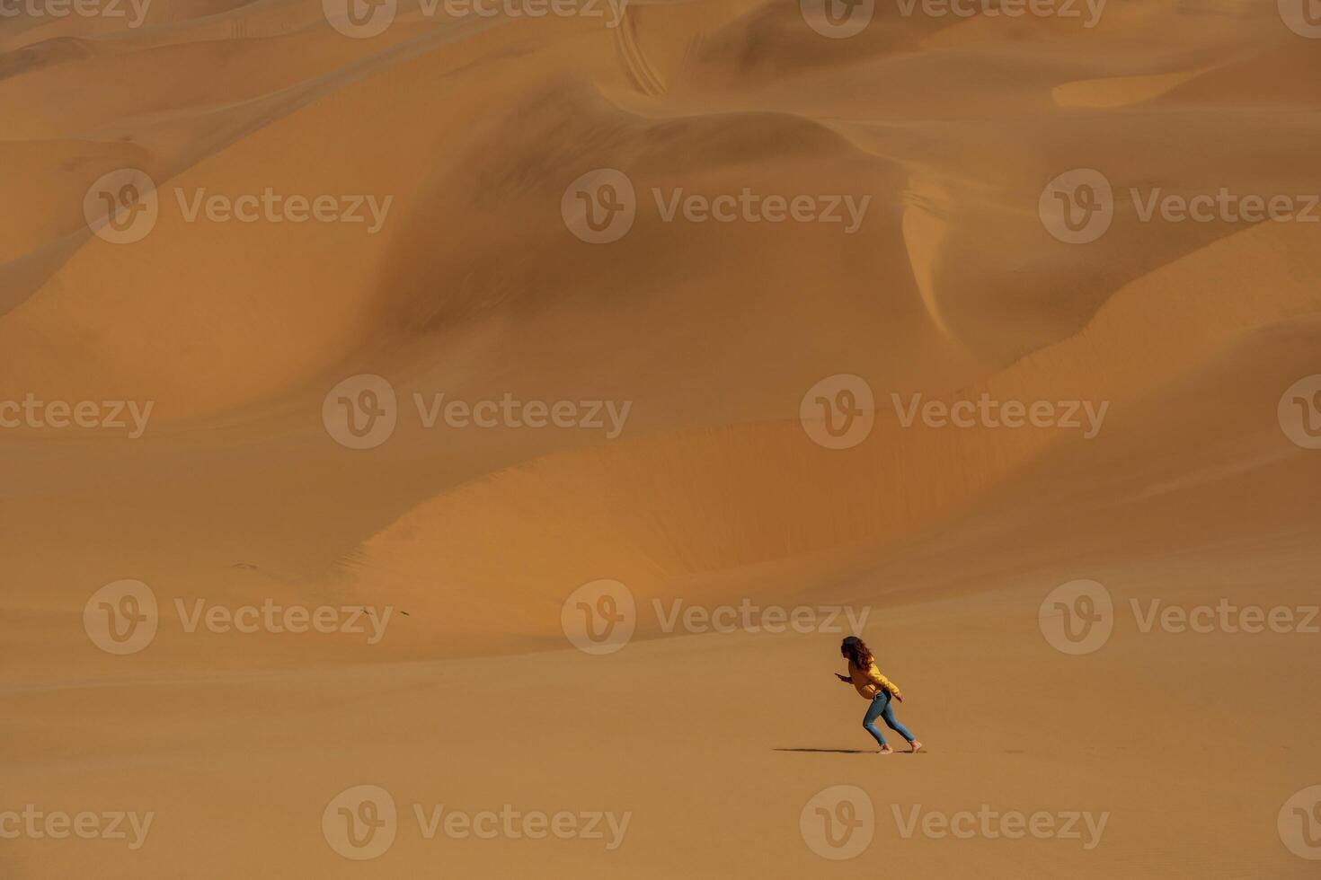 Distant view, of woman that is walking in the sands of Namibia, Africa desert photo