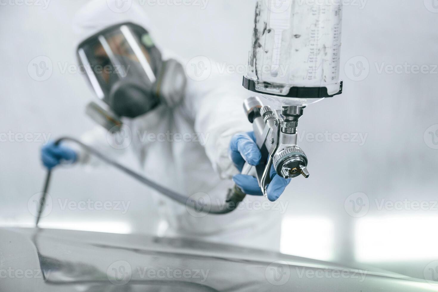 Close, up, view of man that is painting a car by using spray guy photo