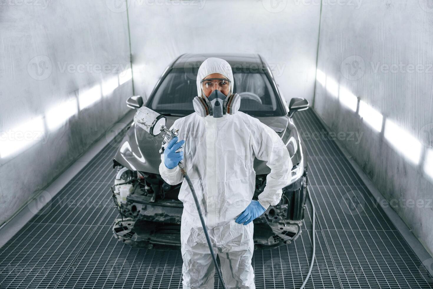Customer service. Man, is ,standing and holding spray gun with paint for automobile photo