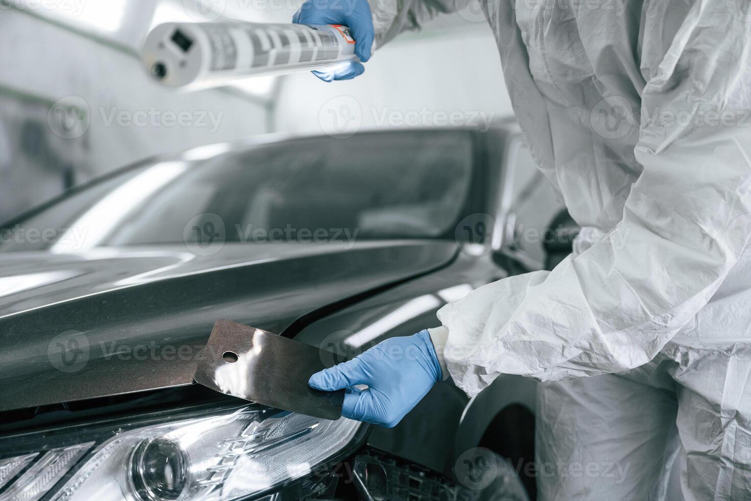 Choosing ,,right color. Garage worker is holding lighting and checking surface of the car photo
