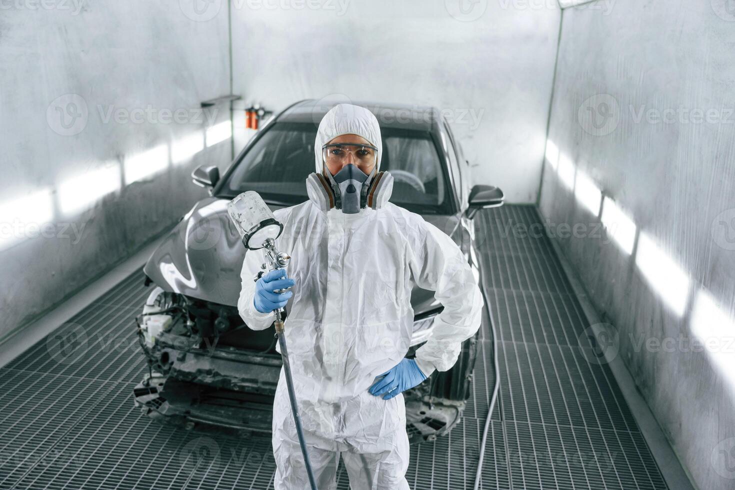 Customer service. Man, is, standing and holding spray gun with paint for automobile photo
