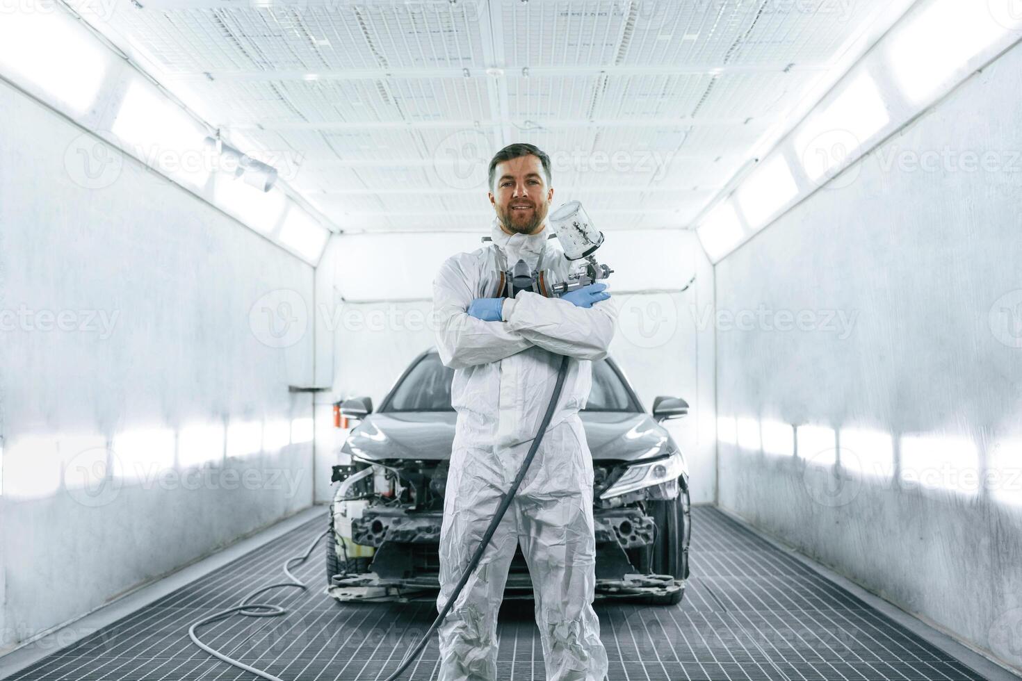 Man is, standing ,,and holding spray gun with paint for automobile photo