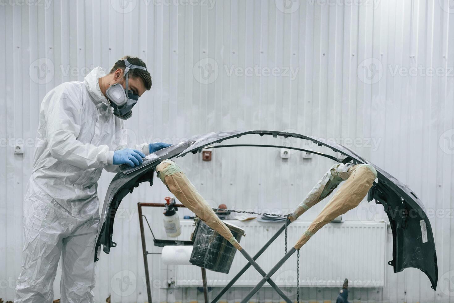 Side view. Repairman is working with ,,carcass of the car in the garage photo