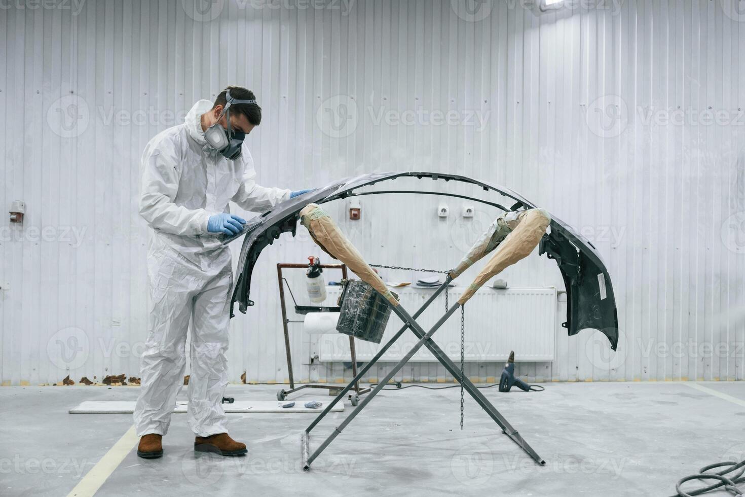Side view. Repairman, is, working with carcass of the car in the garage photo